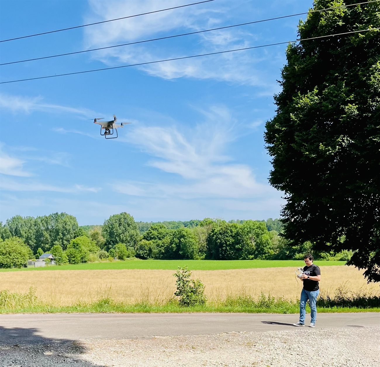 Clément Pesson, télépilote, pilotant son drone au-dessus d'un champ